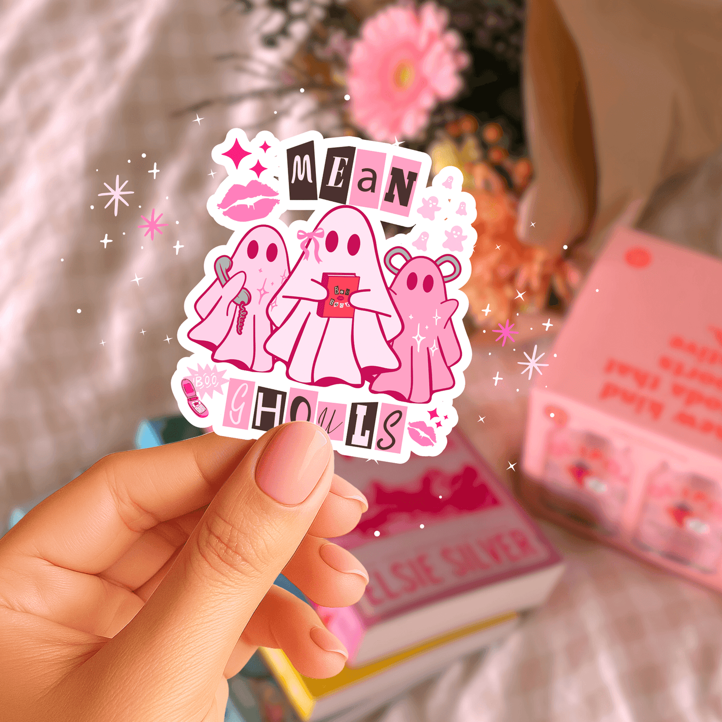Hand holding Mean Girls Pink Ghost Sticker with sparkles, ideal for decorating phones, water bottles, and journals with spooky cute flair.