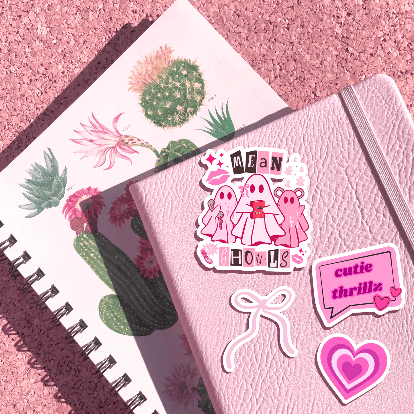 Pink Ghost Sticker on pink leather notebook, paired with other Y2K-style stickers. Durable vinyl for planners and creative journaling.